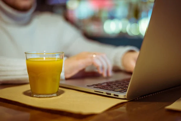 Man drinks juse while working on laptop — Stock Photo, Image