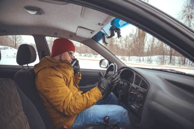 Arabaya akıllı telefon kullanarak arabayı kullanan adam