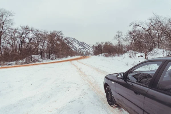 Μοναχικό αυτοκίνητο δρόμου στο χιόνι κόκκινο εξαιτίας μεταλλεύματος — Φωτογραφία Αρχείου
