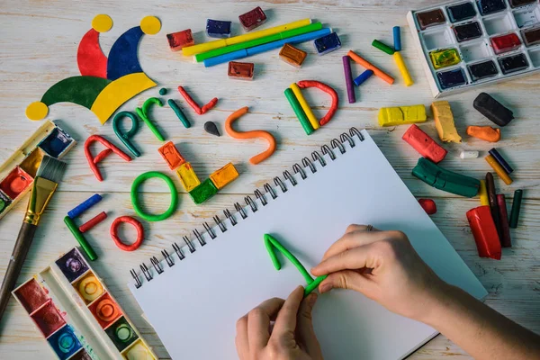 Manos hacen que April Fools Day texto hecho con plastilina — Foto de Stock