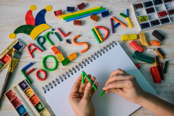 Hands make April Fools Day text made with plasticine — Stock Photo, Image