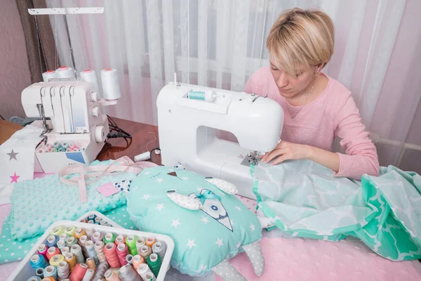 Beautiful woman seamstress sew on the sewing machine clothes. — Stock Photo, Image