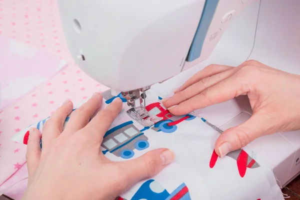 Womans hands with dress at sewing machine — Stock Photo, Image
