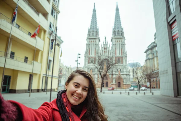 Joven bonita mujer tomar selfie en frente de gótico iglesia — Foto de Stock