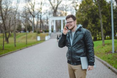 Yang adam dizüstü bilgisayar ile telefon