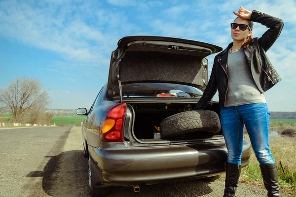 kadın trys tekerleği değiştirmek için bagajdan tak.