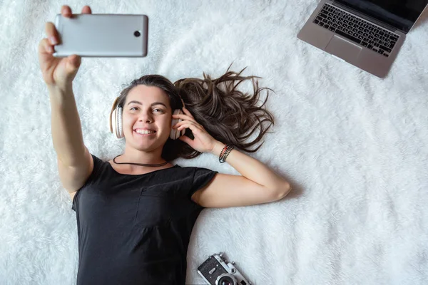 Γυναίκα λήψη selfie στο κρεβάτι, μουσική — Φωτογραφία Αρχείου