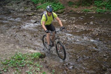 Bisiklet ile genç atlet geçerken su bariyer