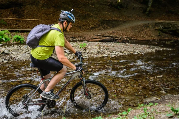 自転車に若い選手交差水バリア — ストック写真