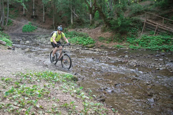 Bisiklet ile genç atlet geçerken su bariyer