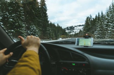 Bir direksiyon simidi ve bulanık yol sürücüleri ellerde