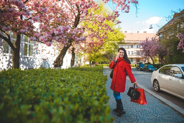 Vrouw staat met paperbags en praten over de telefoon — Stockfoto