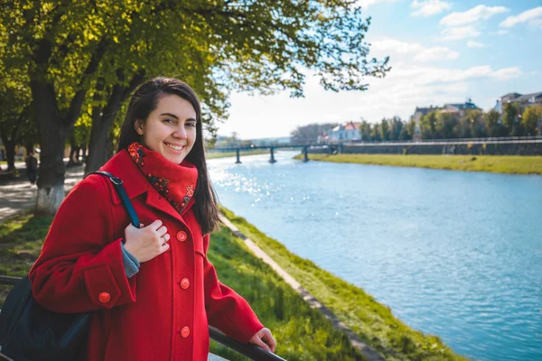 Portrét šťastný usmívající se žena stojící nedaleko řeky město — Stock fotografie