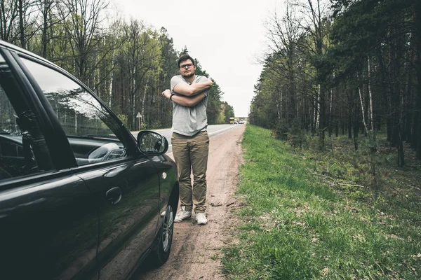 Yang homem stratching perto de carro depois de longa estrada — Fotografia de Stock