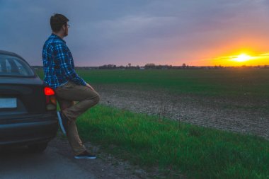 Araba gezisi adam sunrice karayolu üzerinde bakmak için durur