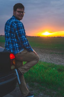 Araba gezisi adam sunrice karayolu üzerinde bakmak için durur