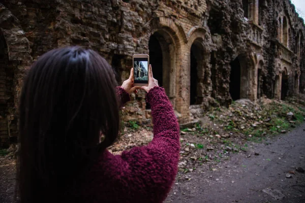 Молодая женщина-туристка фотографирует старые руины — стоковое фото