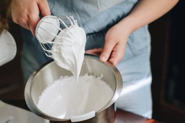 Genç kadın bir mikser kullanarak bir pasta pişirme