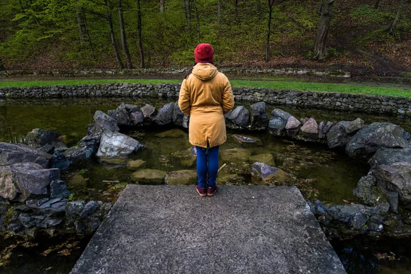 Femeia stă lângă lac în parcul orașului și crede — Fotografie, imagine de stoc
