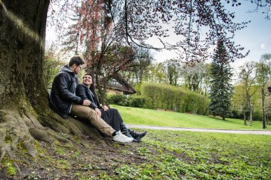 Çift ağaç altında günbatımı üzerinde oturur.