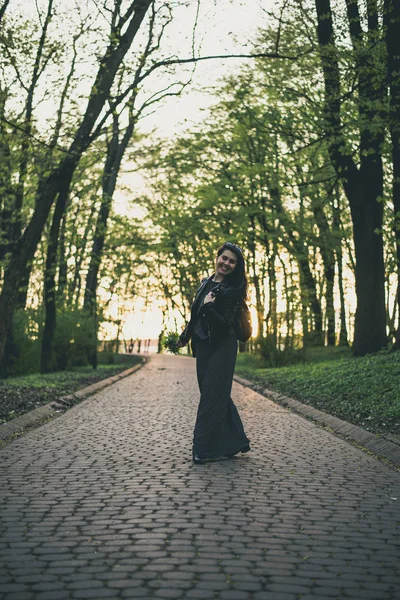손에 꽃 공원으로 산책 하는 여자 — 스톡 사진