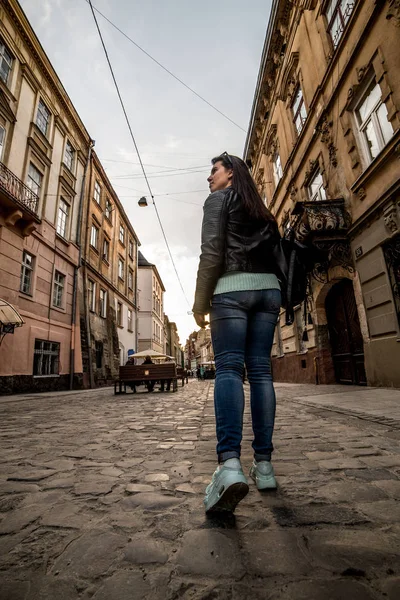 Женщина, идущая по старому европейскому городу — стоковое фото