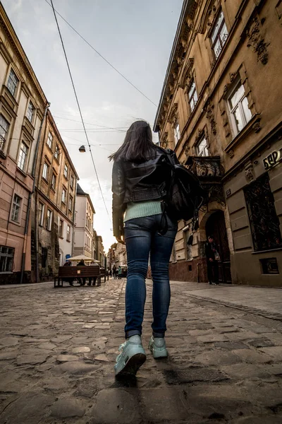 Женщина, идущая по старому европейскому городу — стоковое фото