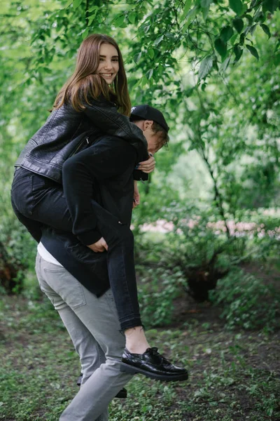 Couple playing in the park while getting a piggy back ride — Stock Photo, Image