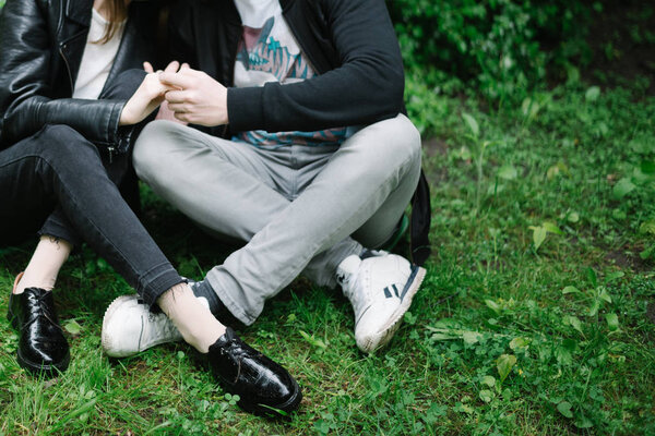 legs of couple that sitting at the park