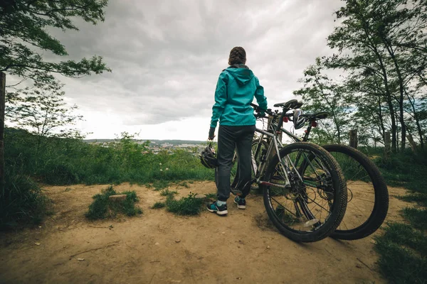 丘の上の自転車の女性が立っています。 — ストック写真