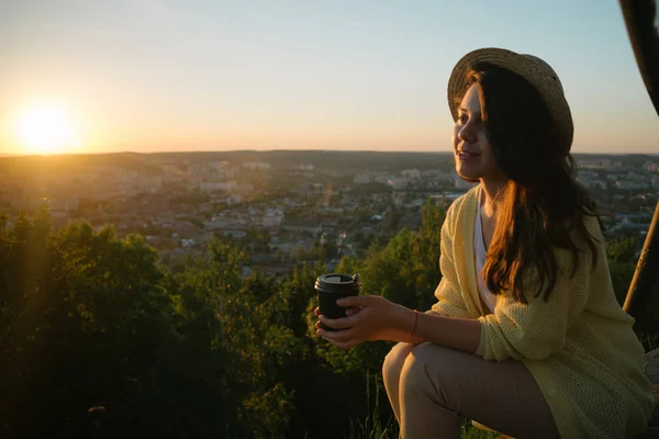 Frau sitzt auf dem Hügel und schaut auf den Sonnenuntergang — Stockfoto