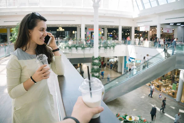 Jovem mulher falando ao telefone enquanto passeia no shopping — Fotografia de Stock