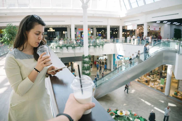 Mujer joven hablando por teléfono mientras camina centro comercial —  Fotos de Stock