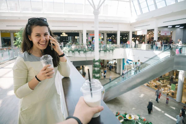 Young woman talking on the phone while walking mall — Stock Photo, Image