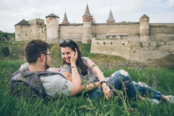 Lindo casal encontra-se no chão em frente ao castelo velho — Fotografia de Stock