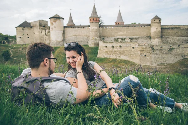 Pareja encantadora se encuentra en el suelo frente al viejo castillo — Foto de Stock