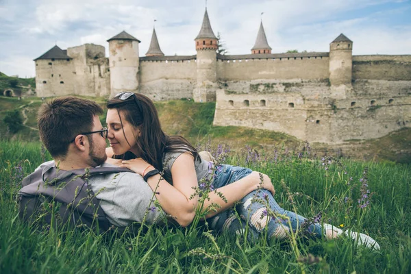 Прекрасная пара лежит на земле перед старым замком — стоковое фото