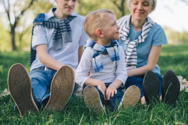 Усміхнена сім'я сидить на ковдрі — стокове фото