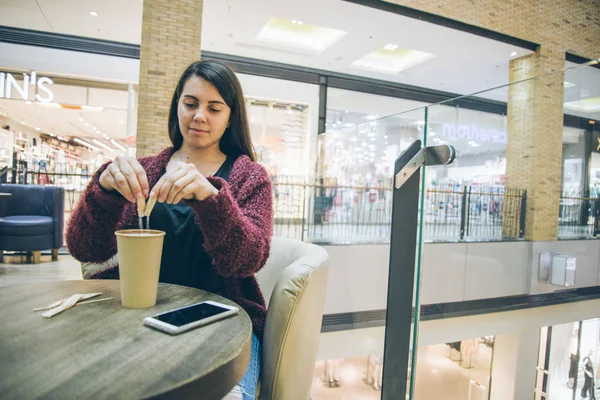 युवा महिला कॉफी कप में चीनी डाल रही है — स्टॉक फ़ोटो, इमेज