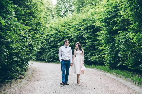 Hombre y mujer caminando en el parque en vestido de elegancia — Foto de Stock