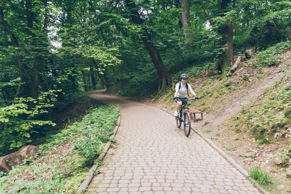 Kobieta jazda rowerem w parku miejskim — Zdjęcie stockowe