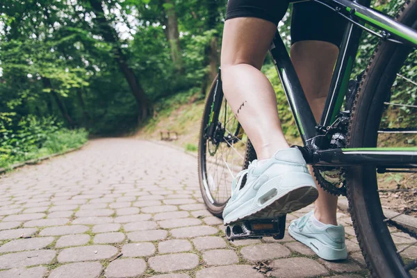 Perna de mulheres com sujo de óleo da cadeia na bicicleta — Fotografia de Stock