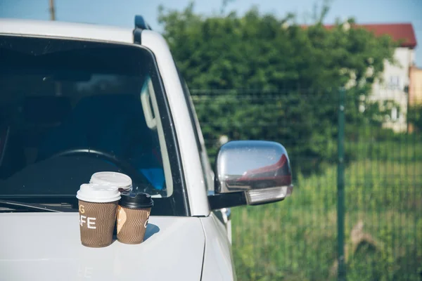 3 Cups of coffee on car hood