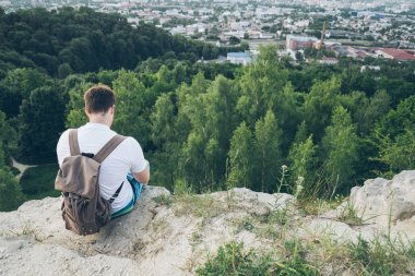 üstünde belgili tanımlık tepe ve düşünerek adam oturur