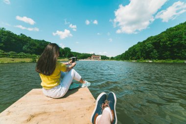 Romantik kırmızı şarap ile pier üzerine oturan Çift.