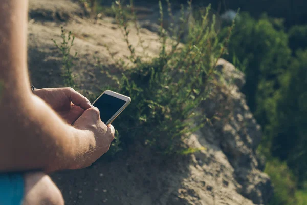 Man sits on the ground chating on the phone — Stock Photo, Image