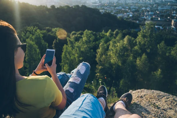 Frau mit Mann sitzt oben auf dem Hügel und genießt Blick auf den Sonnenuntergang — Stockfoto