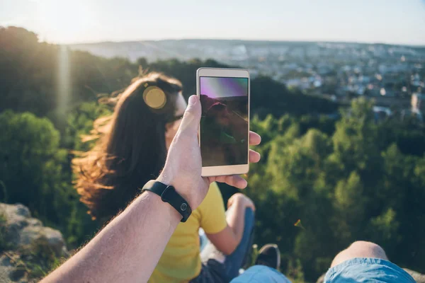 Frau mit Mann sitzt oben auf dem Hügel und genießt Blick auf den Sonnenuntergang — Stockfoto