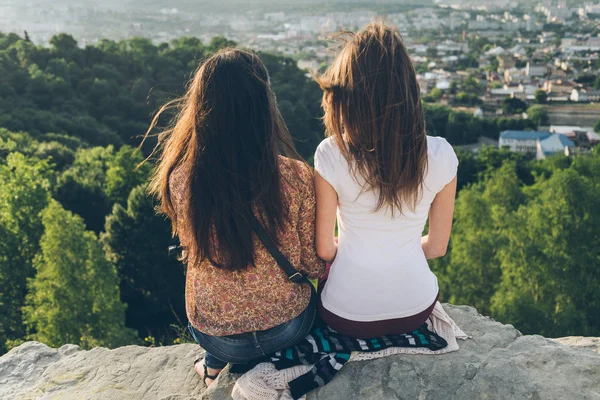 Dos mujeres sentadas en la cima y mirando el paisaje de la ciudad — Foto de Stock