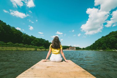 kadın bir göl iskelede oturuyordu